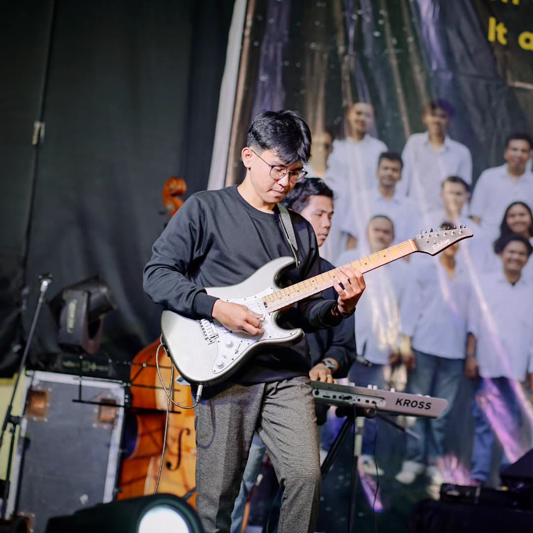 Zyho Sinaga memainkan gitar elektrik di atas panggung