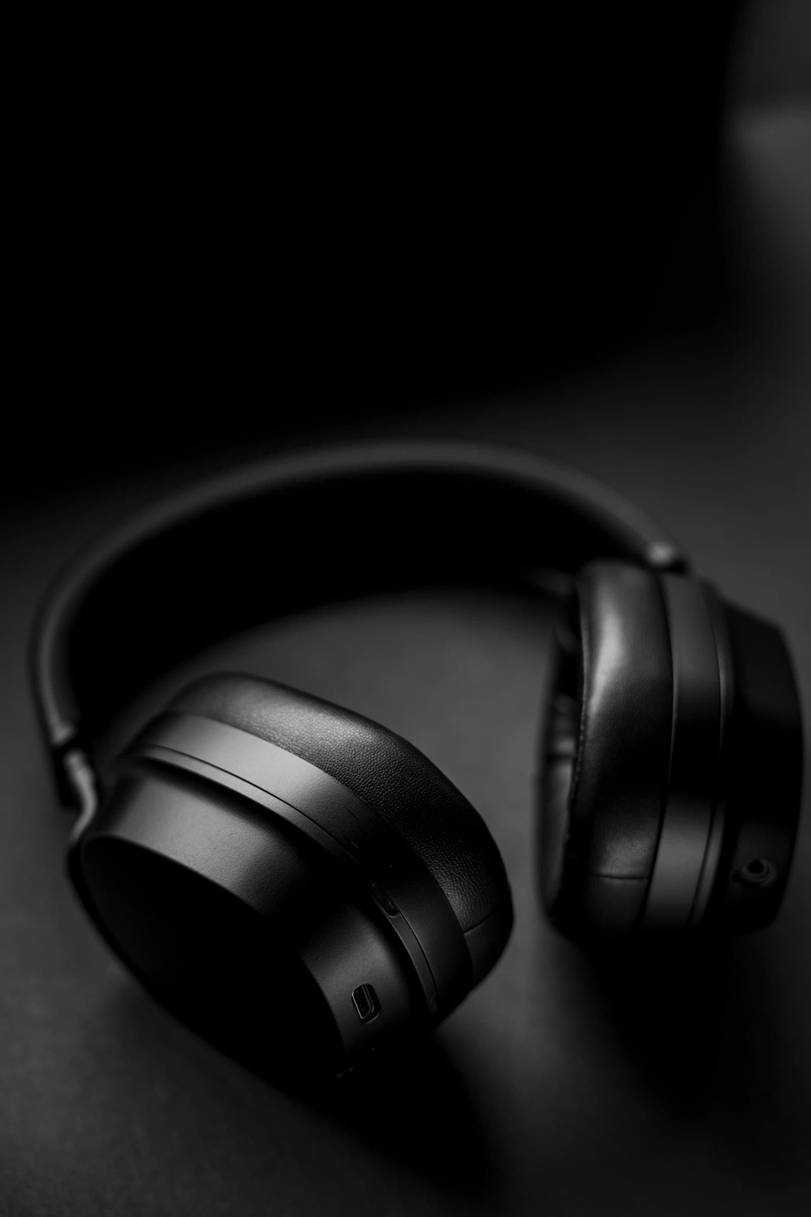Headphone studio hitam di permukaan gelap